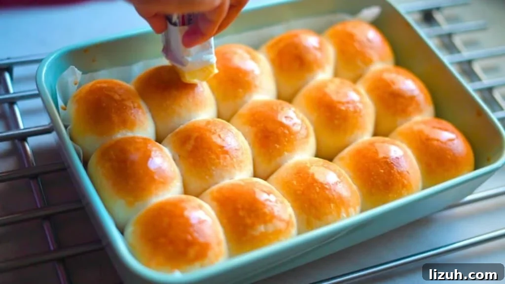 Fluffy Sourdough Dinner Rolls Recipe for Soft, Tangy Bread 8 applying butter on sourdough dinner rolls