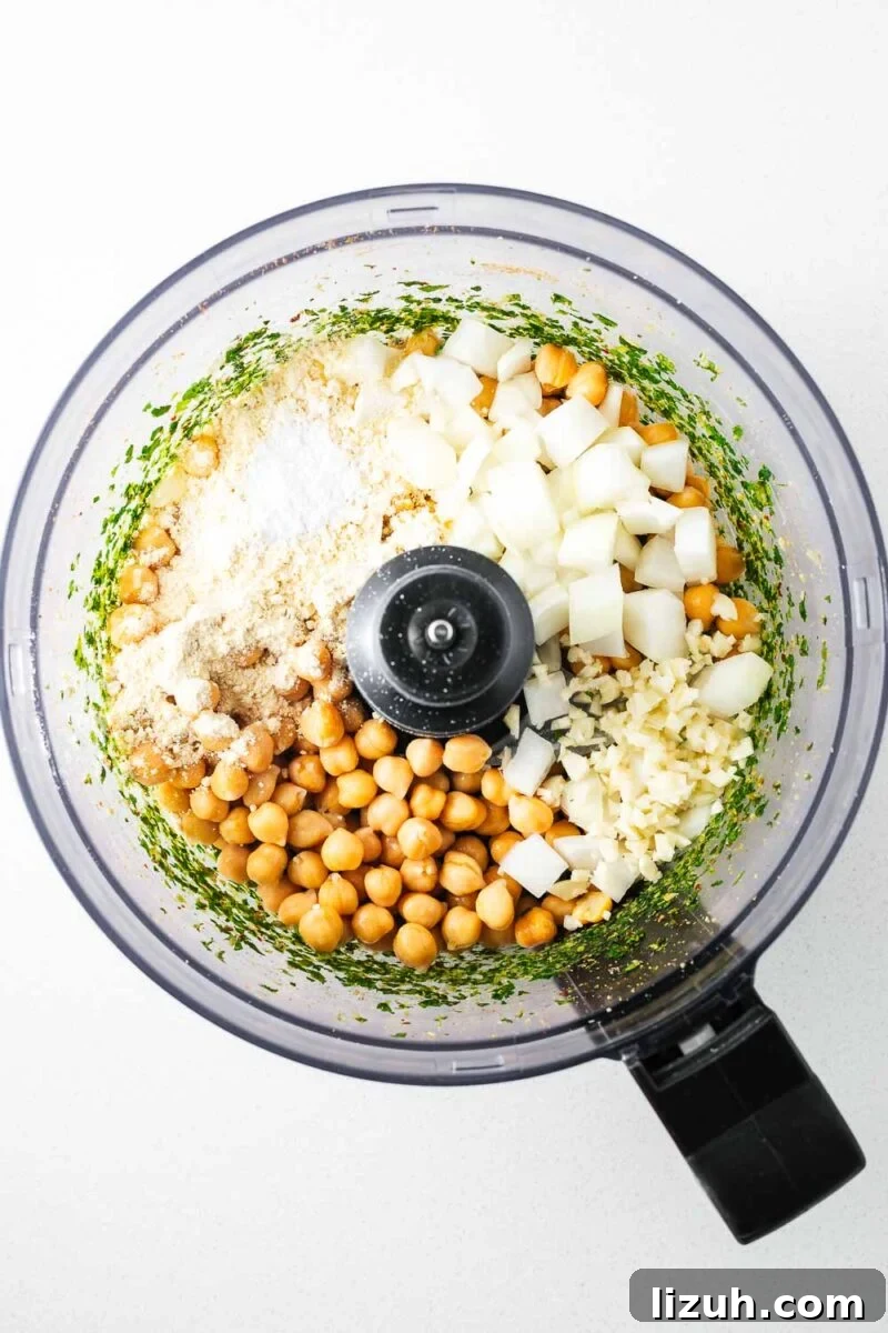 Crispy Oven-Baked Falafel Using Canned Chickpeas 7 Canned chickpeas and further falafel ingredients in a food processor bowl viewed from above.