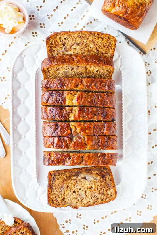 Six-Banana Banana Bread on a platter sliced into pieces. 