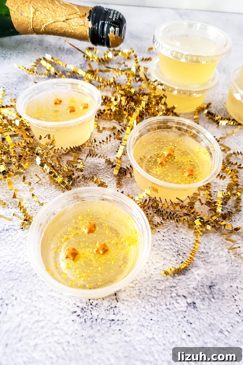 New Year's Eve gold star sprinkles on top of champagne jello shot cups.