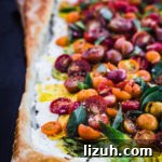 Lemony Ricotta Tomato Tart with Flaky Puff Pastry Crust 5 Colorful tomato puff pastry tart, out of the oven and topped with other summer produce; side angle shot.