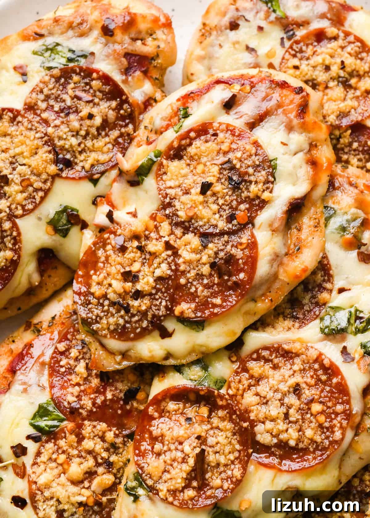 Making pizza chicken: close-up photo of completed meal being served on a white speckled plate.