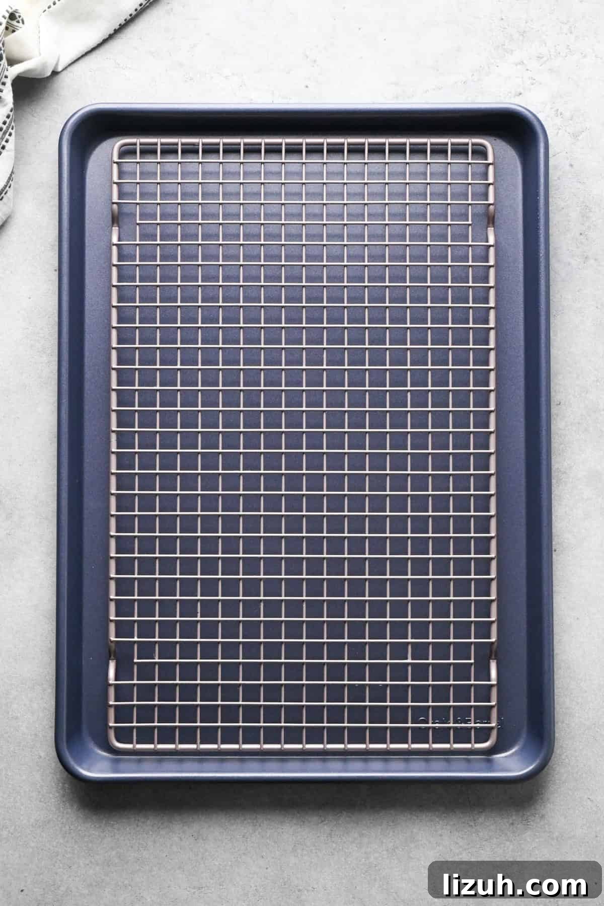 Making pizza chicken: overview photo of a silver cooling rack placed on top of a dark baking sheet.