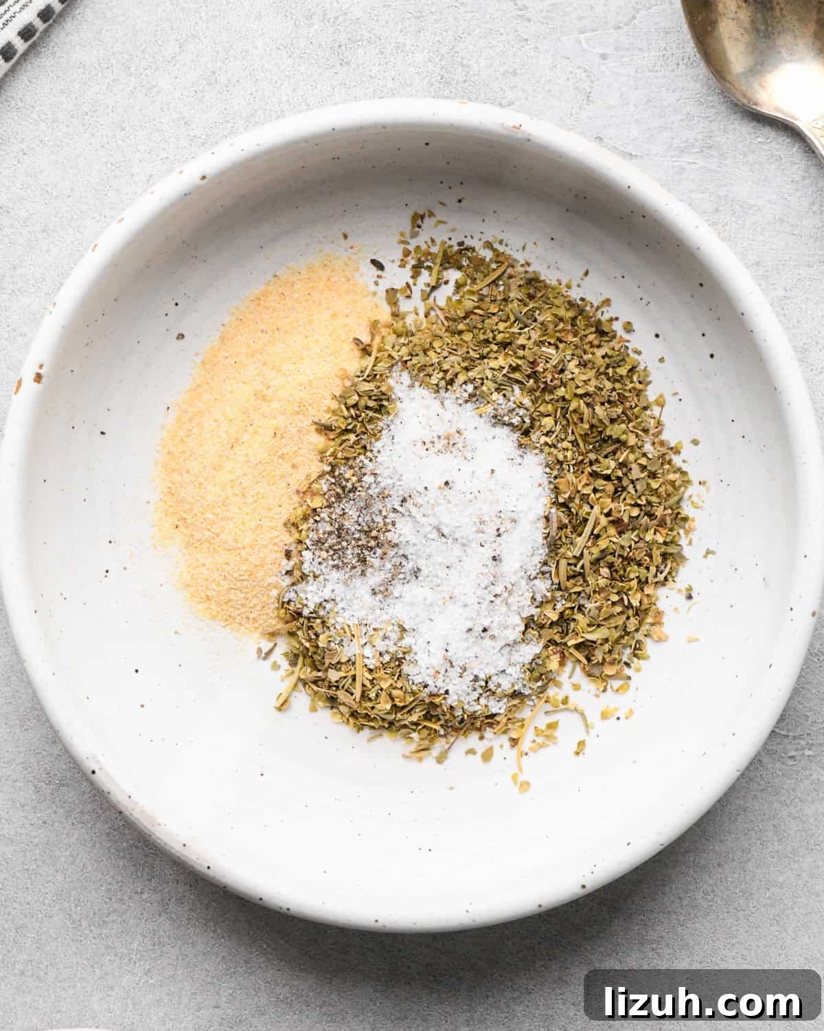 Making pizza chicken: overview photo of recipe spices sitting in a white bowl on a countertop.